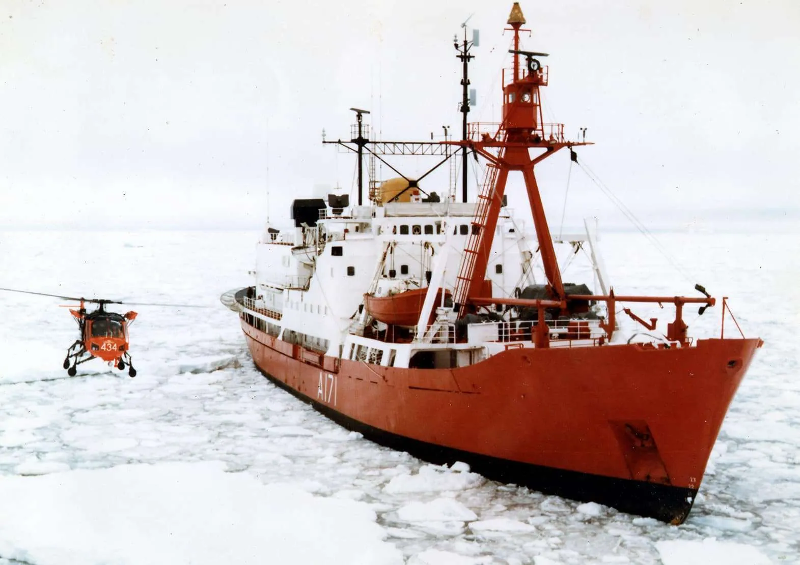 HMS Endurance (A171) working through the pack ice with her helicopter up. Ice patrol ship, floating weather station, and — though nobody aboard would have put it this way — a data-collection platform for a question nobody had finished asking.